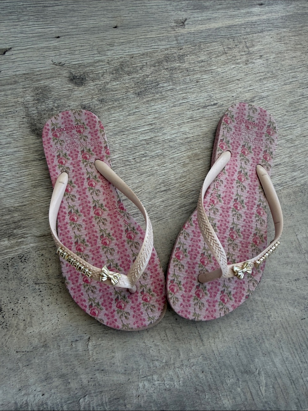 LoveShackFancy Pink Floral Flip Flops with Gold Bow Accents